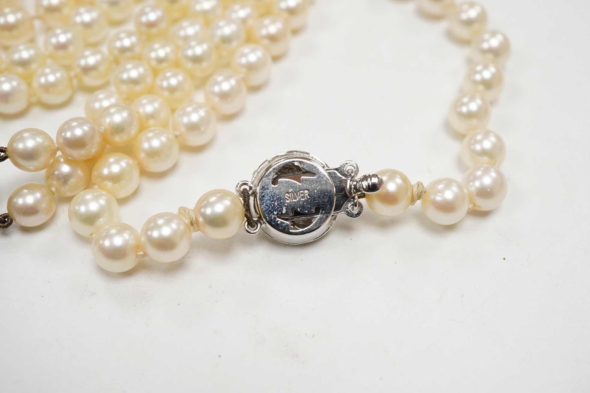 A Mikimoto double strand cultured pearl choker necklace, with cultured pearl set white metal clasp, 38cm, together with a single strand cultured pearl necklace, with cultured pearl set white metal clasp engraved 'silver'